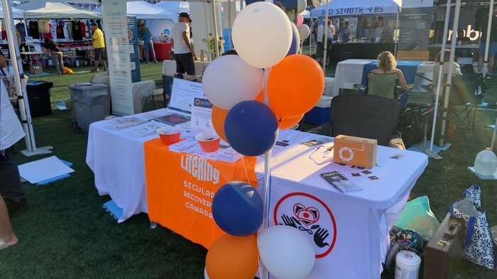 The LifeRing Canada table at SoberFest Victoria, with orange LifeRing banner, brochures and balloons